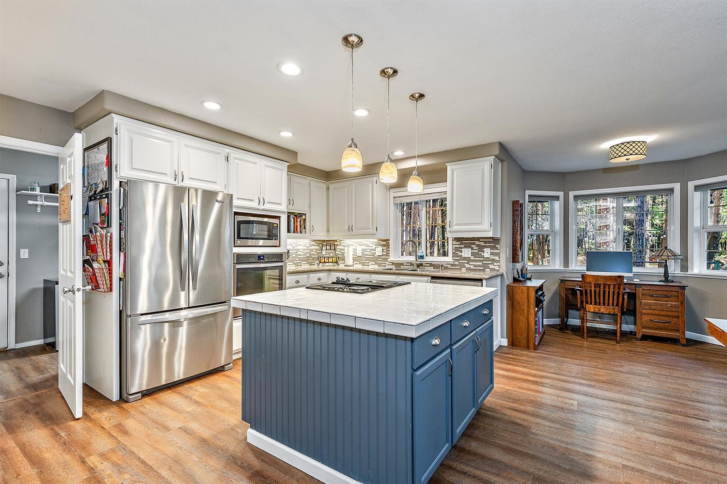 4623 Dick George Road Cave Junction, OR 97523 - Photo 6 of 26 a kitchen with stainless steel appliances granite countertop a refrigerator a stove and a wooden floors