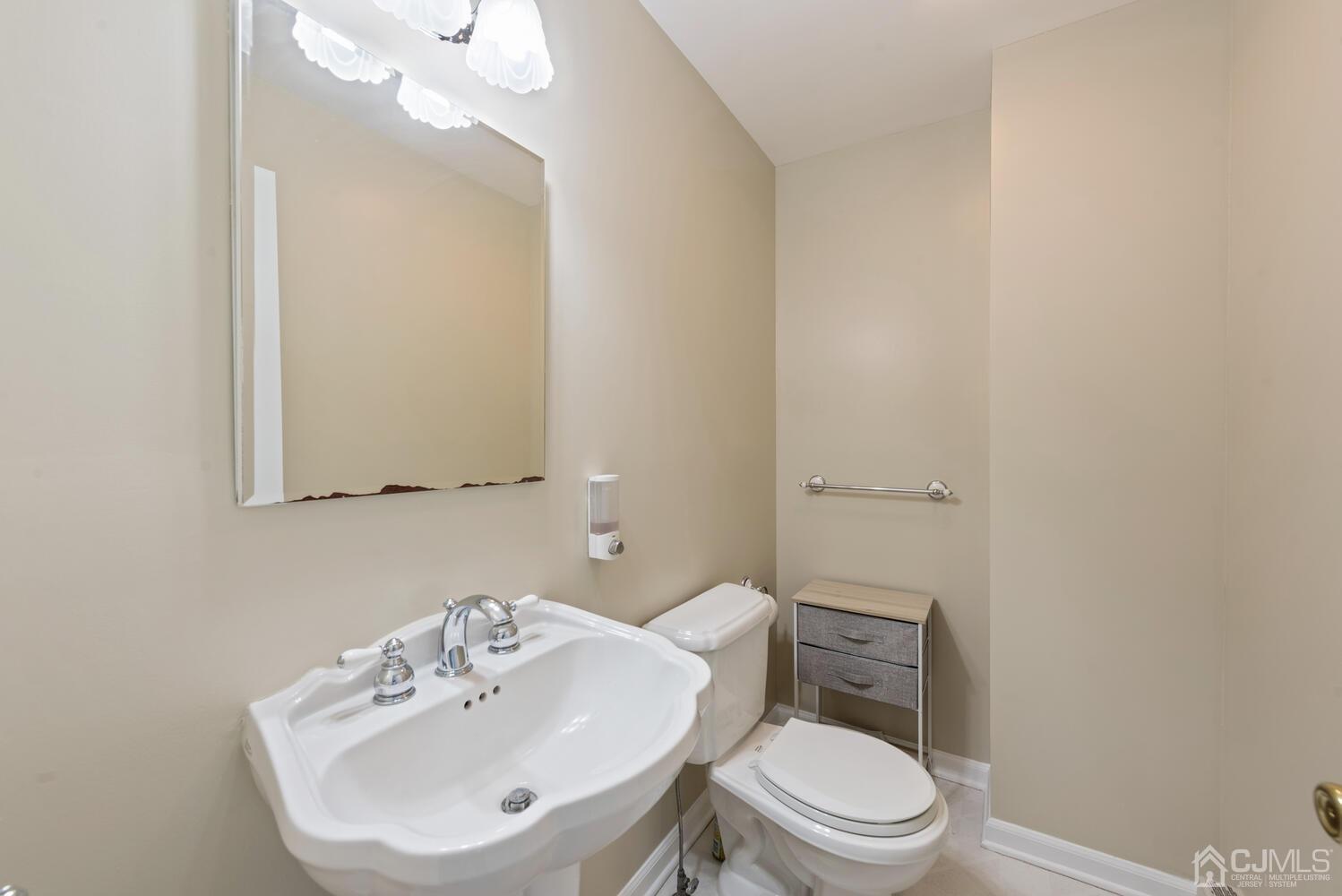 76 Orchard Road Middlesex, NJ 08846 - Photo 14 of 31 a bathroom with a toilet a sink a mirror and vanity
