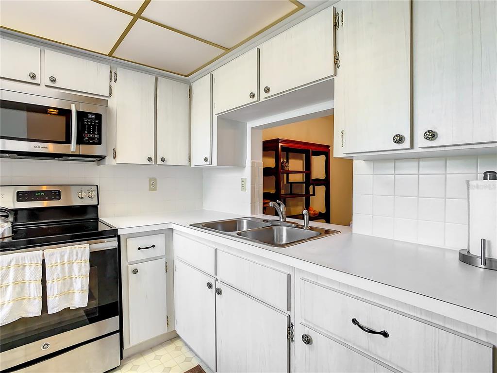 4230 Redcliff Place, Unit 4230 New Port Richey, FL 34652 - Photo 3 of 42 a kitchen with stainless steel appliances granite countertop white cabinets and window