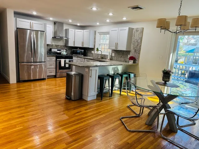 a large kitchen with stainless steel appliances granite countertop a stove a sink and a refrigerator