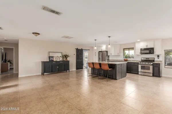 a large white kitchen with a large window and stainless steel appliances