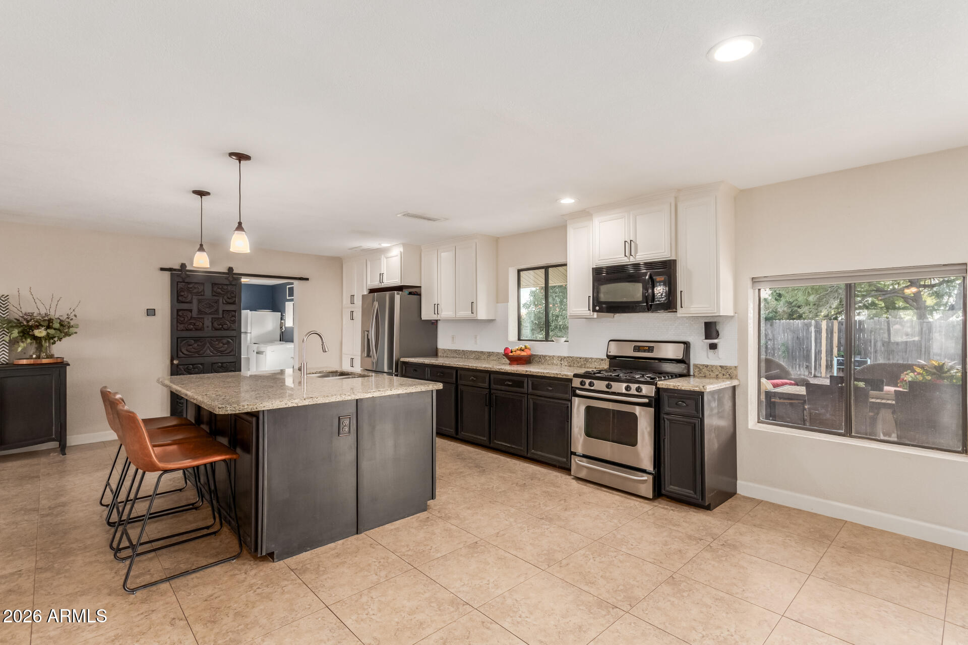 313 West Saddle Mountain Road Phoenix, AZ 85086 - Photo 17 of 54 a kitchen with stainless steel appliances granite countertop a stove top oven a sink dishwasher a dining table and chairs with wooden floor