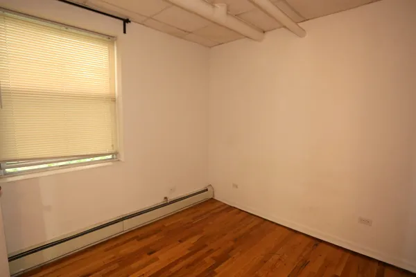 a view of a small space with wooden floor and a window