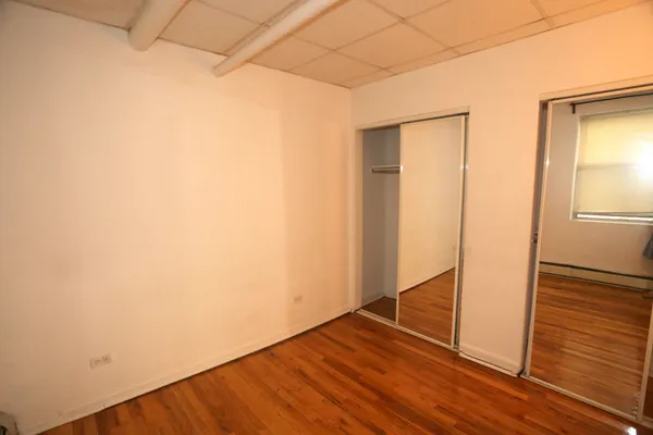an empty room with wooden floor and closet