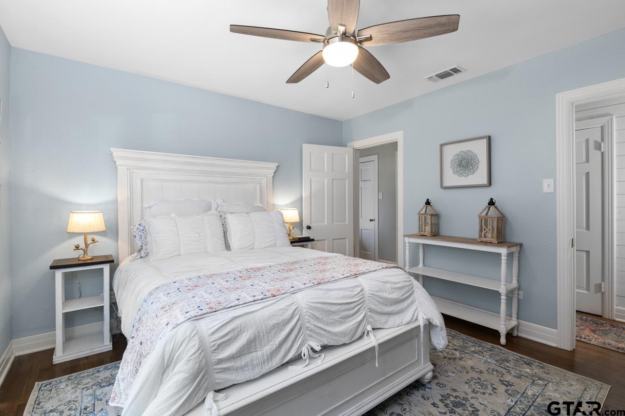 403 East Houston Street Tyler, TX 75701 - Photo 28 of 44 a bedroom with a bed and a chandelier