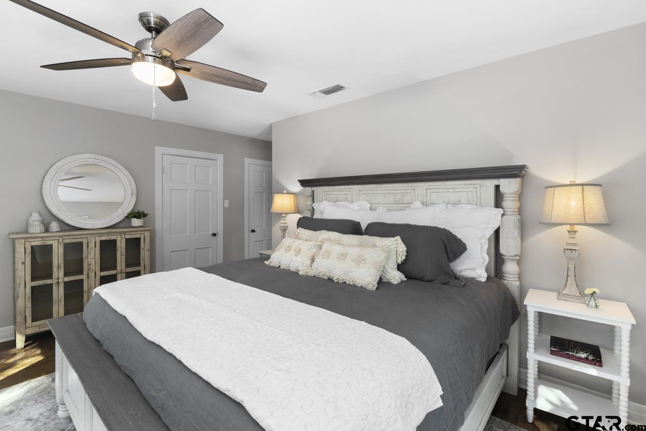 403 East Houston Street Tyler, TX 75701 - Photo 31 of 44 a bedroom with a bed a mirror and a lamp