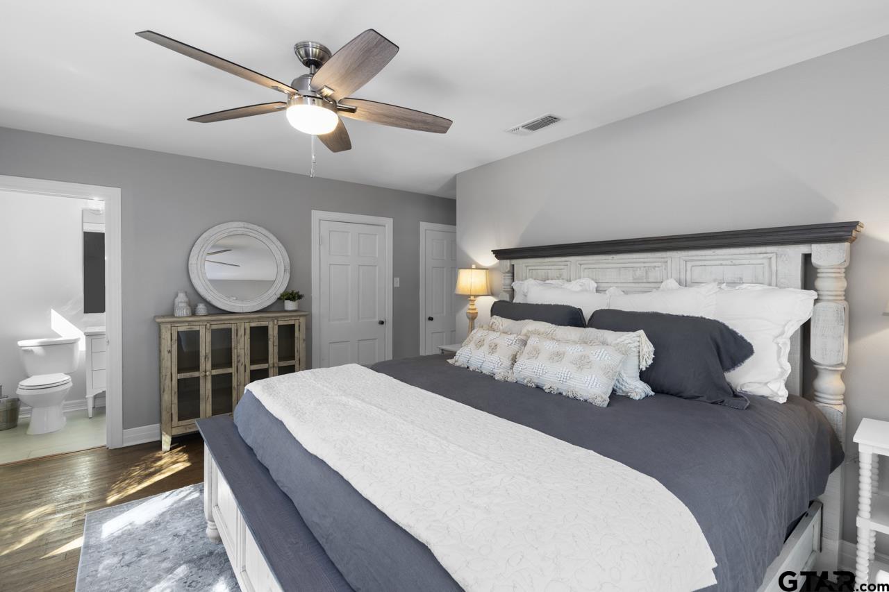 403 East Houston Street Tyler, TX 75701 - Photo 32 of 44 a bedroom with a bed a mirror and a lamp on the table