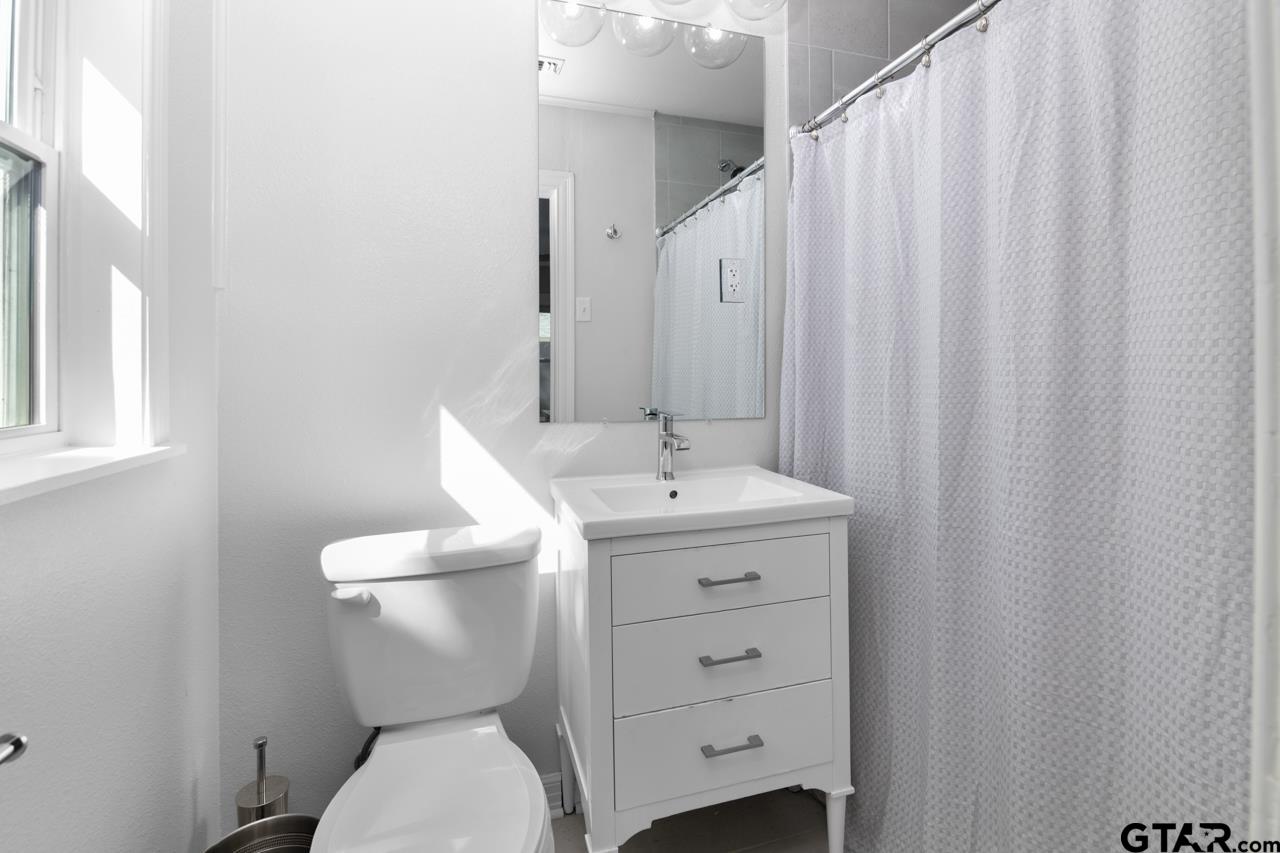 403 East Houston Street Tyler, TX 75701 - Photo 33 of 44 a white toilet sitting next to a bathroom sink