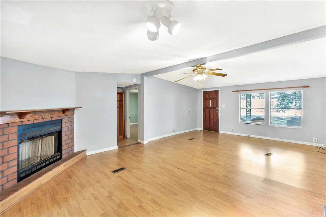1004 Wiles Road Anderson, SC 29625 - Photo 6 of 26 A classic brick fireplace anchors this inviting living space with hardwood flooring.