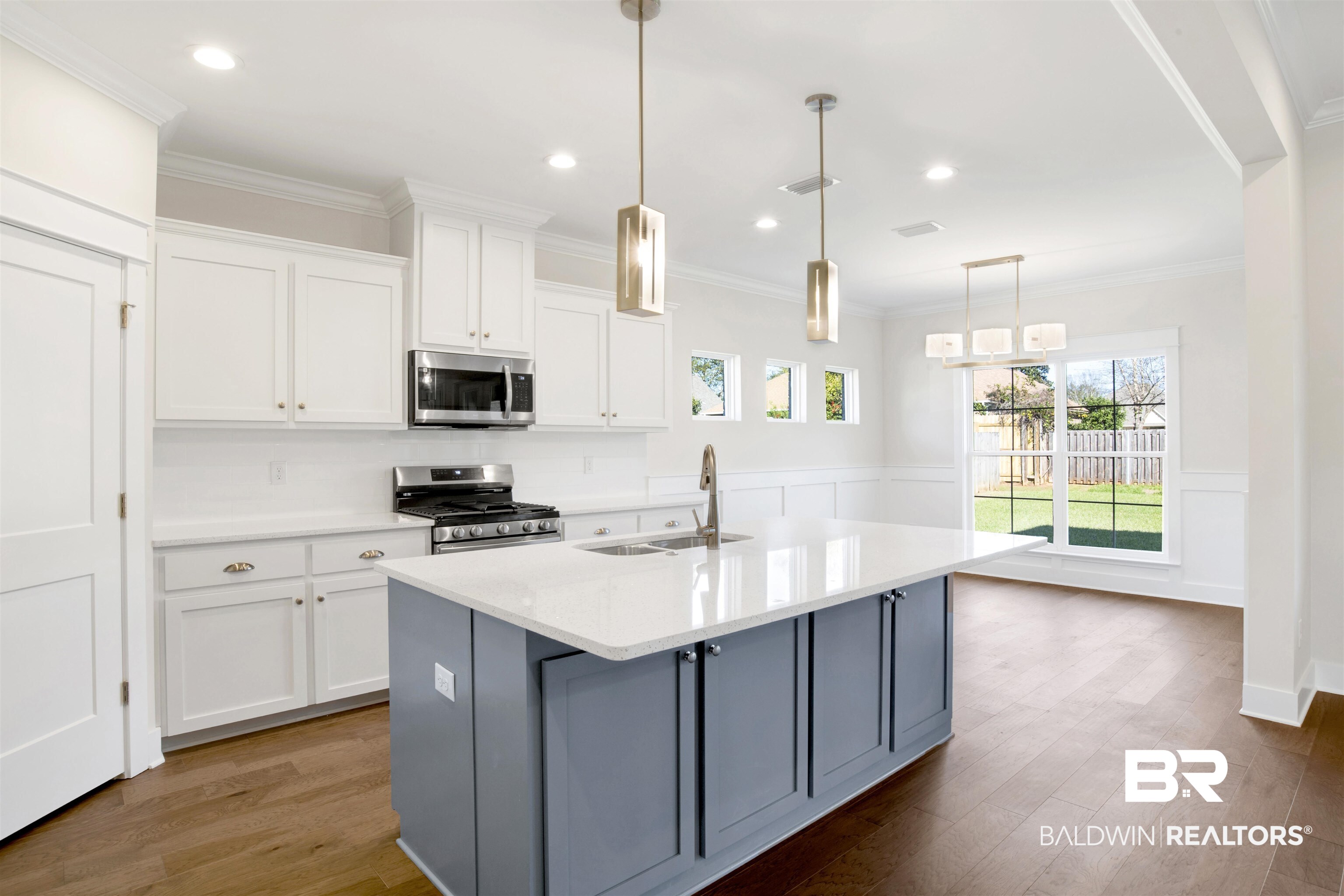 9687 Widgeon Court Daphne, AL 36526 - Photo 12 of 40 Kitchen with white cabinets, stainless steel appliances, a kitchen island with sink, and sink
