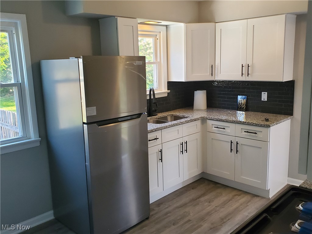 7007 Biddulph Road Brooklyn, OH 44144 - Photo 3 of 16 Kitchen featuring freestanding refrigerator, a sink, plenty of natural light, and white cabinets