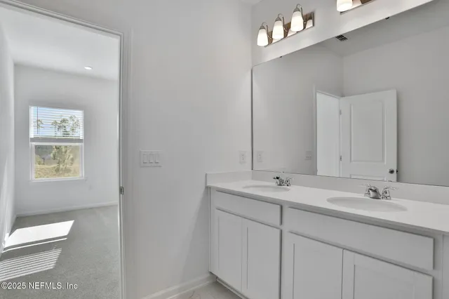 a bathroom with a sink vanity and mirror