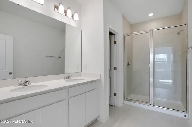 a bathroom with a shower a sink and a mirror