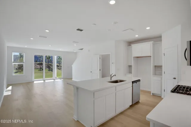 a view of a kitchen with center island and stainless steel appliances