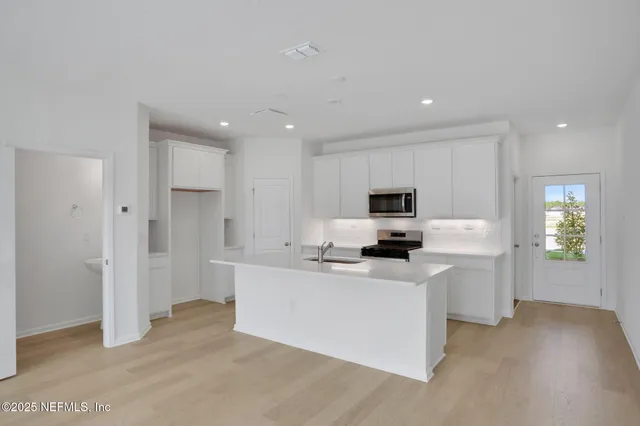 a view of a kitchen with sink refrigerator and wooden floor