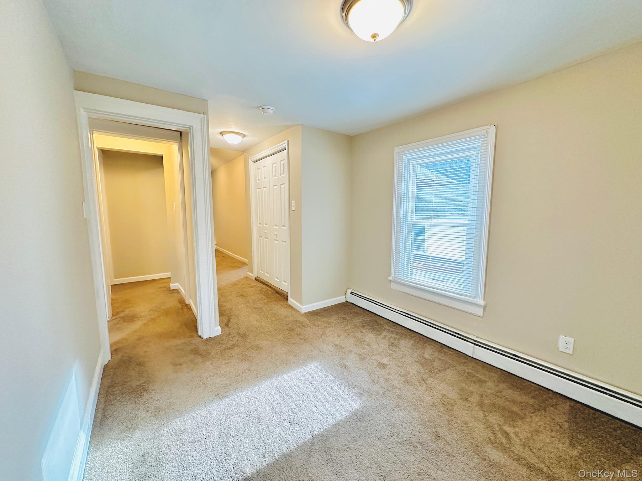181 Mansion Street, Unit 2 Poughkeepsie, NY 12601 - Photo 11 of 20 Unfurnished bedroom with a baseboard heating unit and light carpet