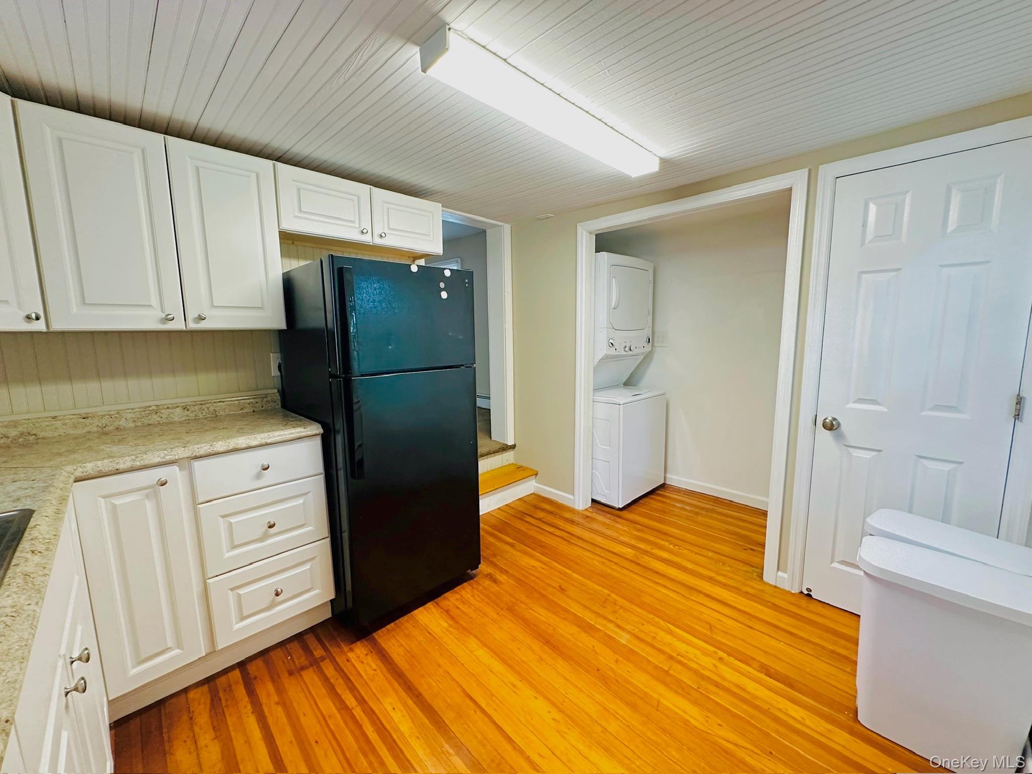 181 Mansion Street, Unit 2 Poughkeepsie, NY 12601 - Photo 5 of 20 Kitchen with white cabinets, freestanding refrigerator, light countertops, light wood finished floors, and wood ceiling