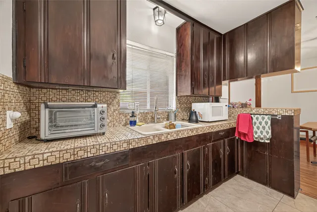 a kitchen with granite countertop a stove a sink and a microwave