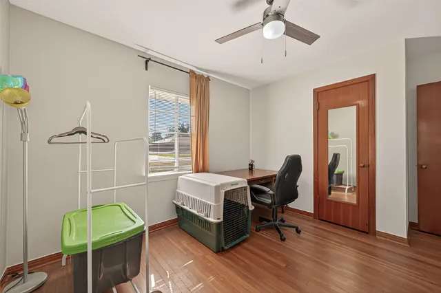 a walk in closet with wooden floor