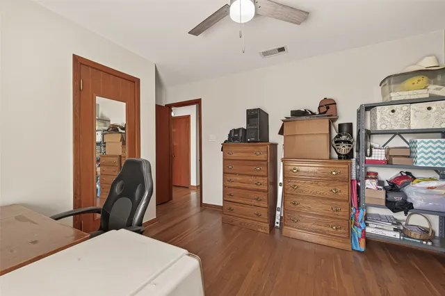 a bedroom with a bed a table and a bookshelf