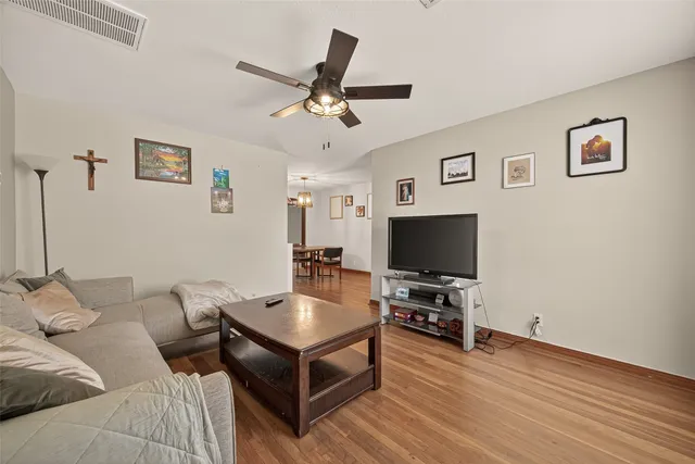 a living room with furniture and a wooden floor
