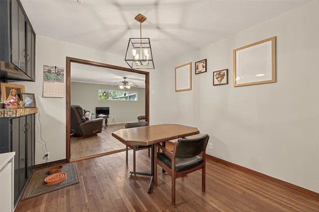 a kitchen with stainless steel appliances a dining table chairs stove refrigerator and cabinets