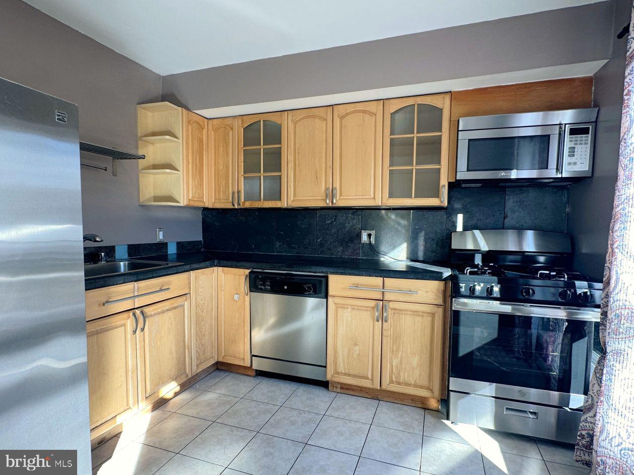 a kitchen with stainless steel appliances granite countertop a stove sink and cabinets