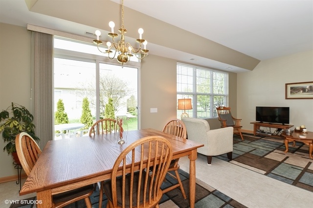 13509 Delaney Road Huntley, IL 60142 - Photo 8 of 15 a view of a dining room with furniture a chandelier and wooden floor