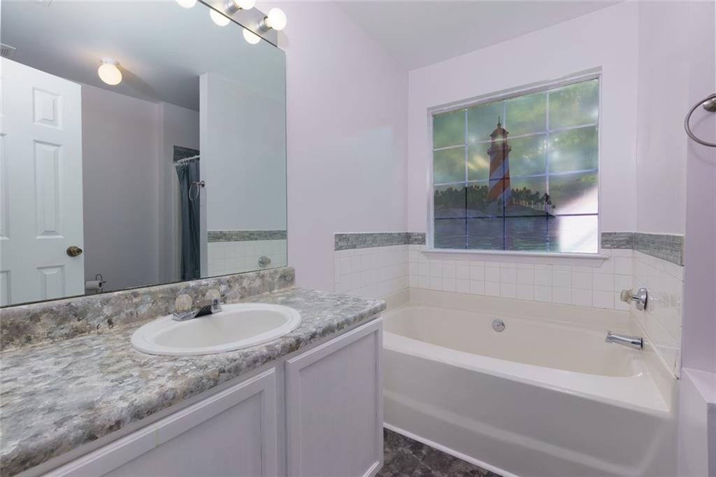 552 Casey's Crossing Winder, GA 30680 - Photo 13 of 26 a bathroom with a granite countertop sink and a mirror