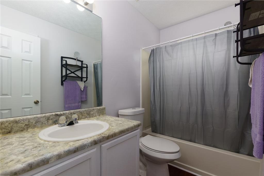 552 Casey's Crossing Winder, GA 30680 - Photo 15 of 26 a bathroom with a granite countertop sink toilet and shower