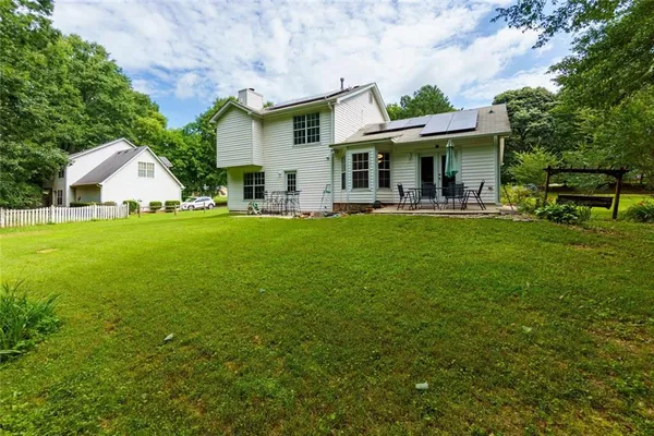 a view of a house with a yard and sitting area