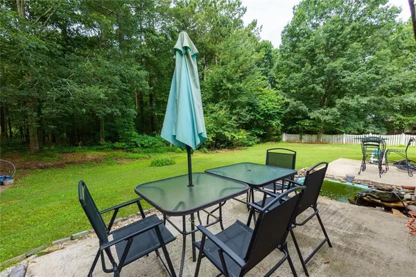 a view of a chairs and table in patio with a small yard