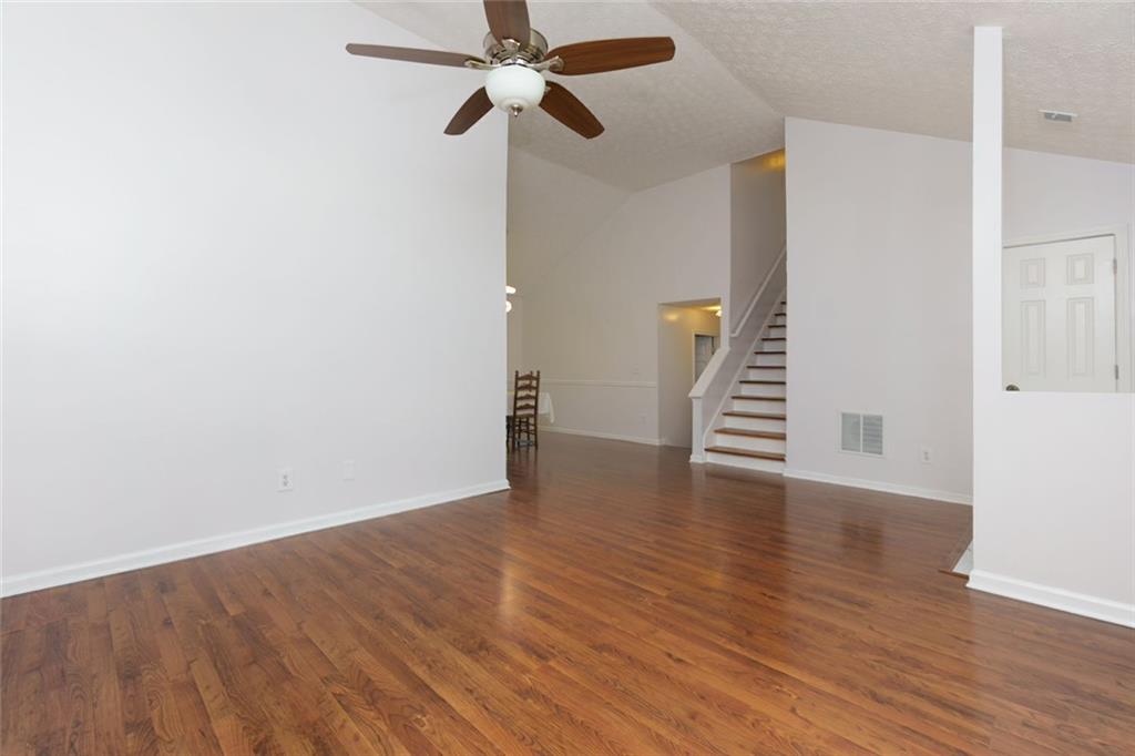 552 Casey's Crossing Winder, GA 30680 - Photo 3 of 26 a view of an empty room with wooden floor and a ceiling fan