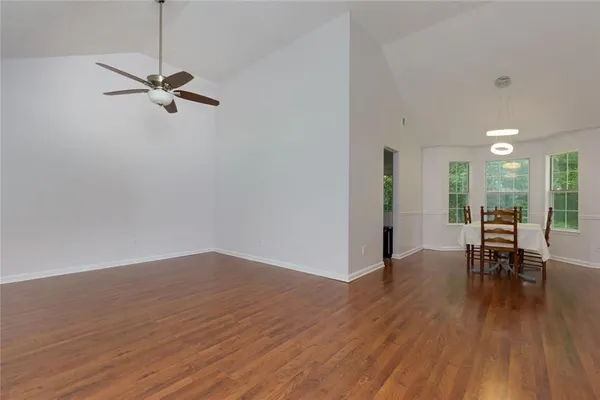 a view of a room with wooden floor and furniture