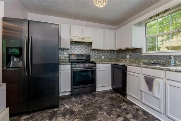 a kitchen with a stove sink and refrigerator
