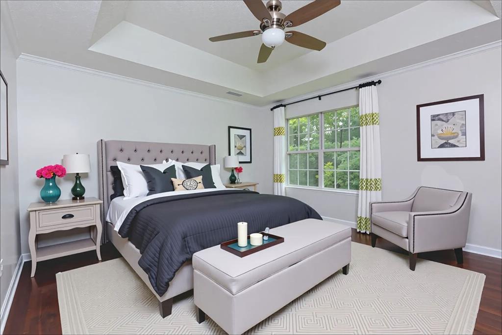 552 Casey's Crossing Winder, GA 30680 - Photo 9 of 26 a bed sitting in a bedroom next to a window with a potted plant on a stool