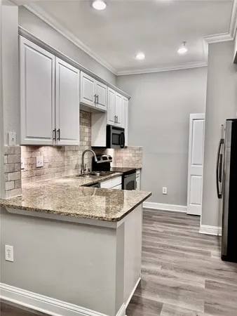 a kitchen with stainless steel appliances granite countertop a sink a stove and a refrigerator