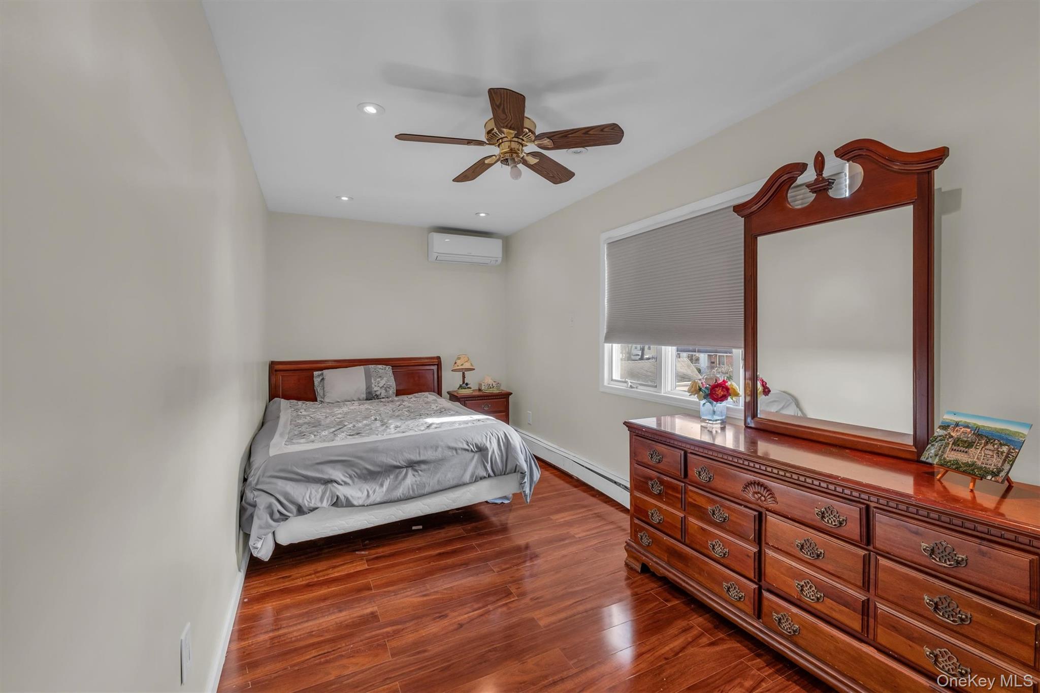95 Liberty Boulevard Valley Stream, NY 11580 - Photo 13 of 17 a bedroom with a bed and a mirror on dresser