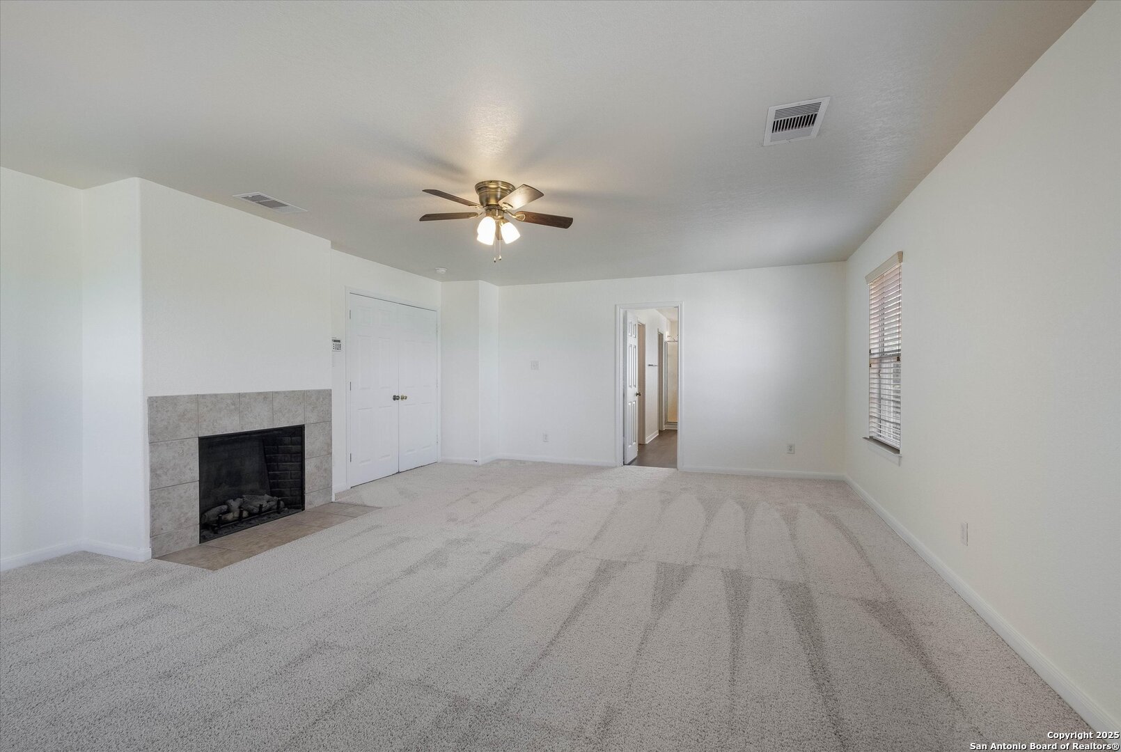 173 Springtree Gate Cibolo, TX 78108 - Photo 11 of 23 an empty room with a fireplace and fan