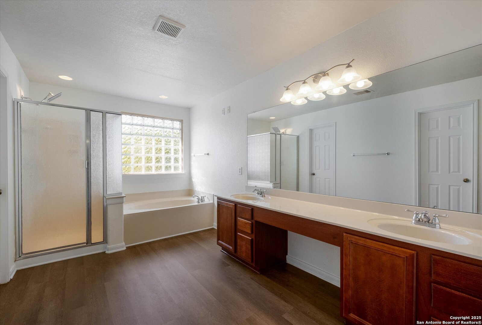 173 Springtree Gate Cibolo, TX 78108 - Photo 12 of 23 a spacious bathroom with a tub double sink and a mirror