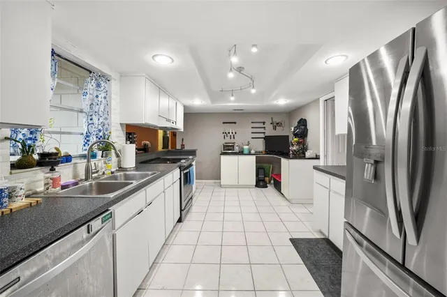 a kitchen with stainless steel appliances granite countertop a refrigerator sink and cabinets