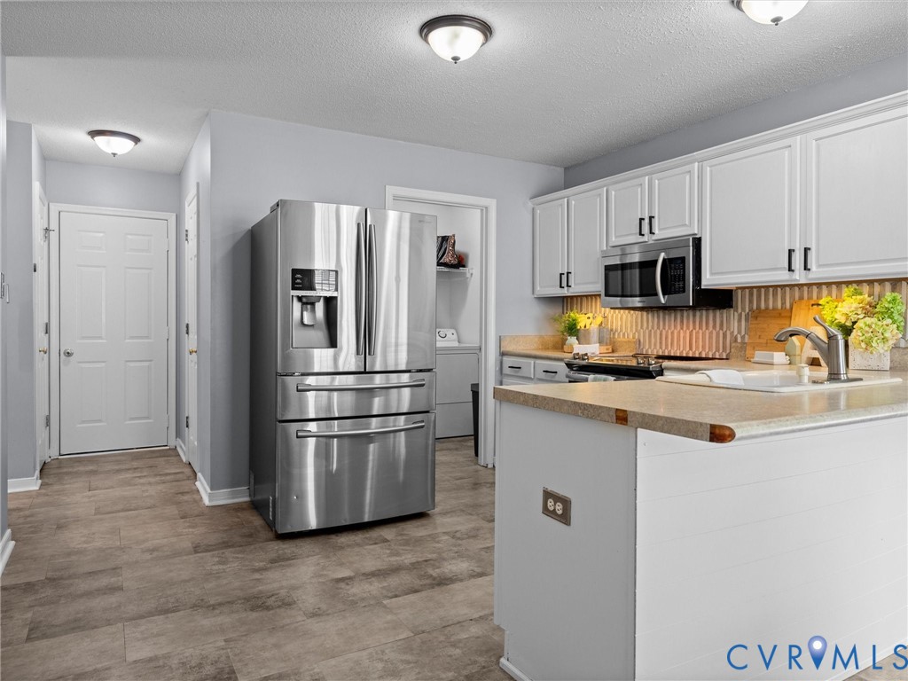 6712 Hedges Road Richmond, VA 23224 - Photo 25 of 34 Kitchen featuring white cabinetry, stainless steel