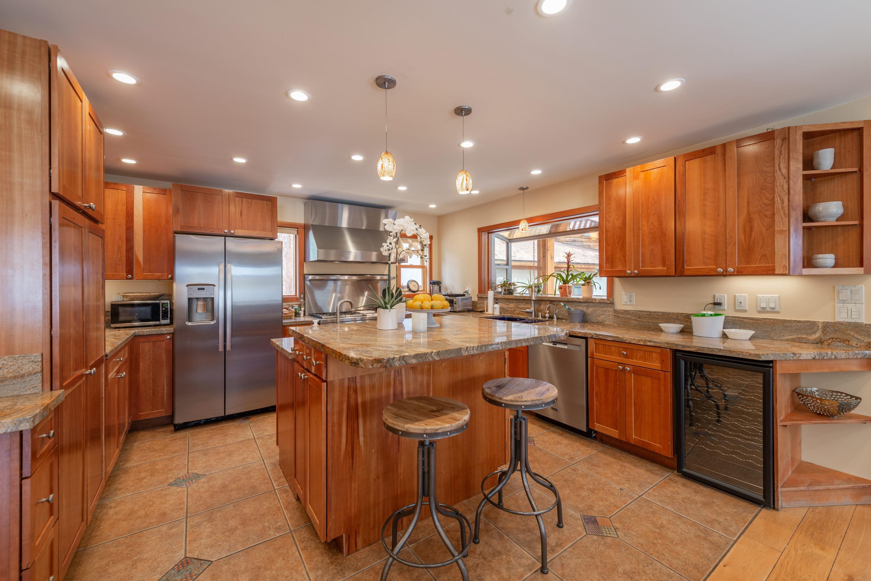 a kitchen with stainless steel appliances granite countertop a refrigerator a sink and a microwave