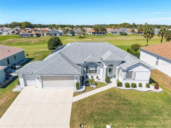 an aerial view of a house with a garden and lake view