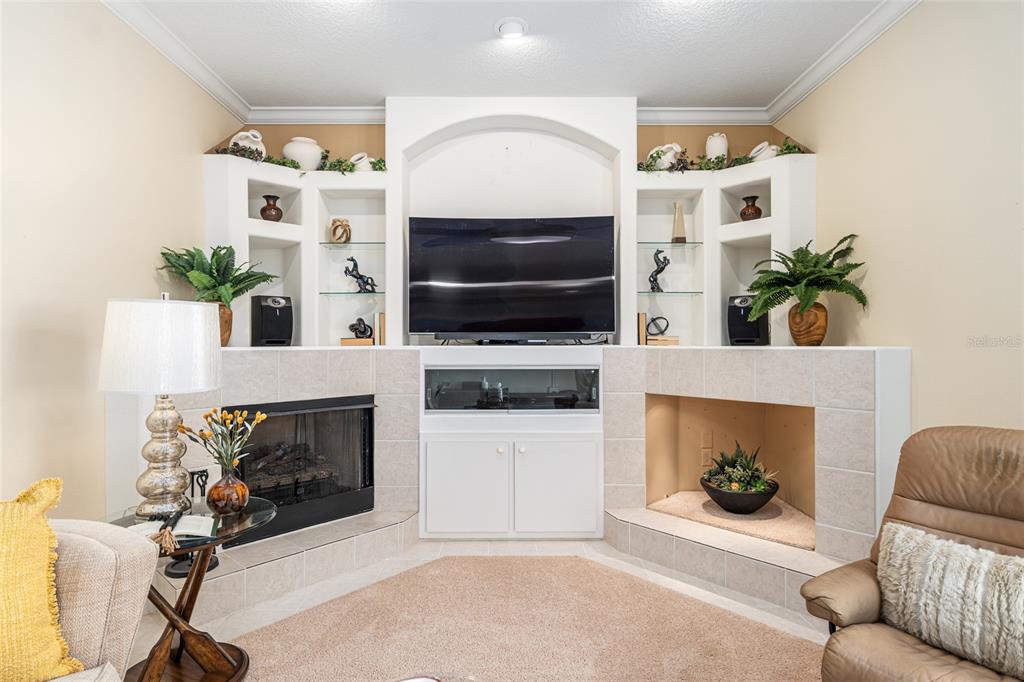5711 Northwest 25th Loop Ocala, FL 34482 - Photo 25 of 91 a living room with furniture a flat screen tv and a fireplace