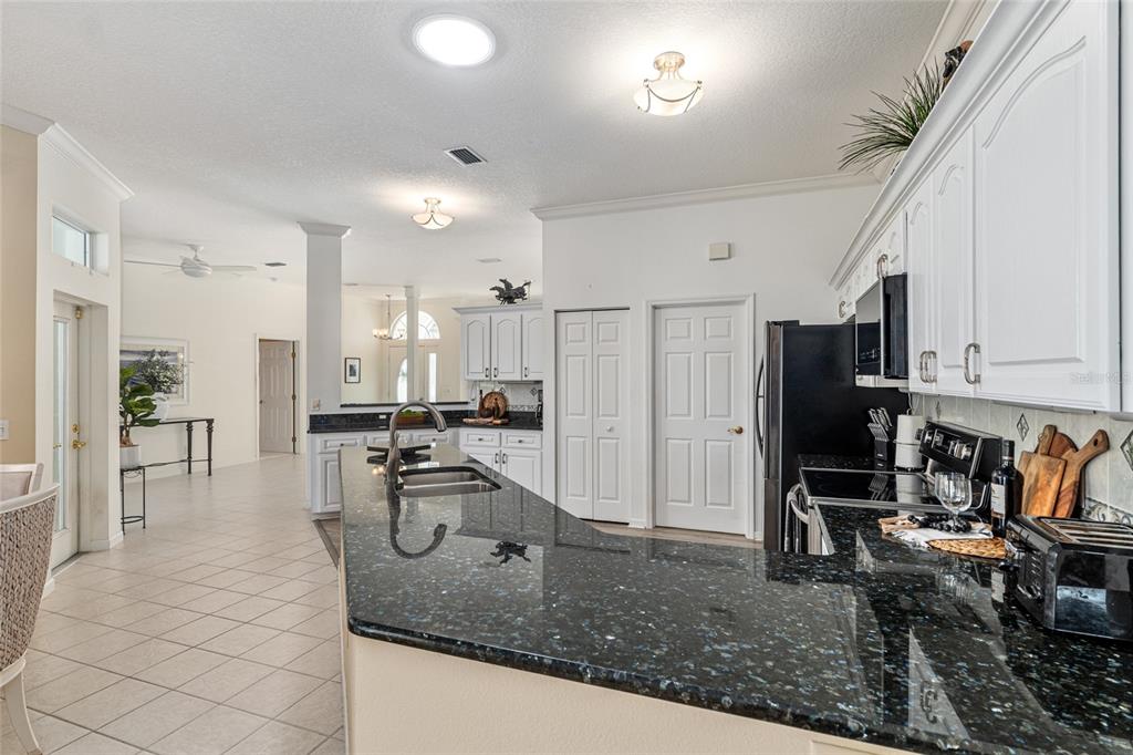 5711 Northwest 25th Loop Ocala, FL 34482 - Photo 31 of 91 a kitchen with stainless steel appliances granite countertop a sink refrigerator and cabinets