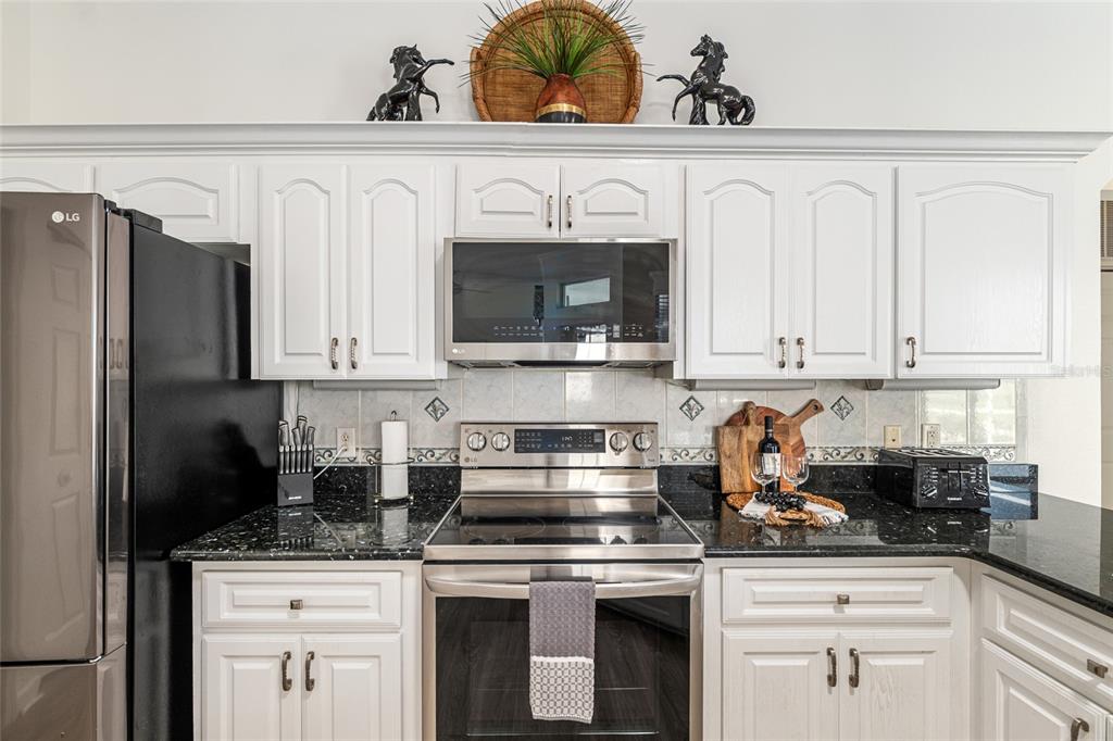 5711 Northwest 25th Loop Ocala, FL 34482 - Photo 36 of 91 a kitchen with white cabinets and stainless steel appliances