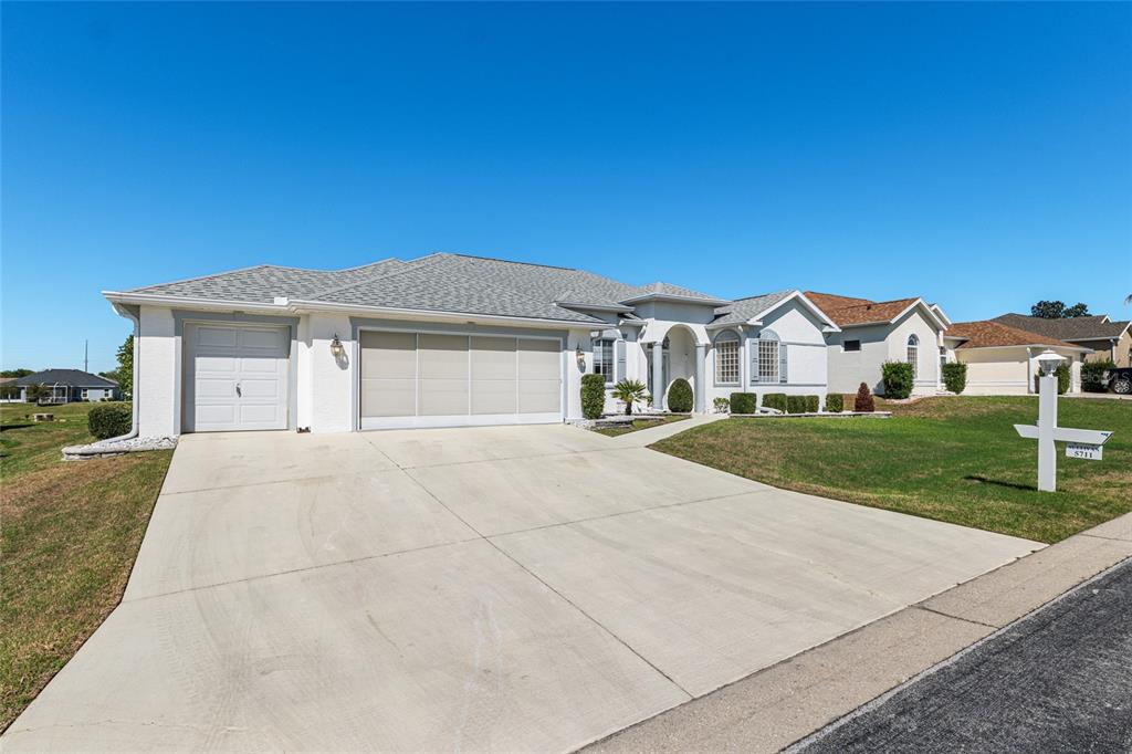 5711 Northwest 25th Loop Ocala, FL 34482 - Photo 7 of 91 a front view of a house with a yard and garage