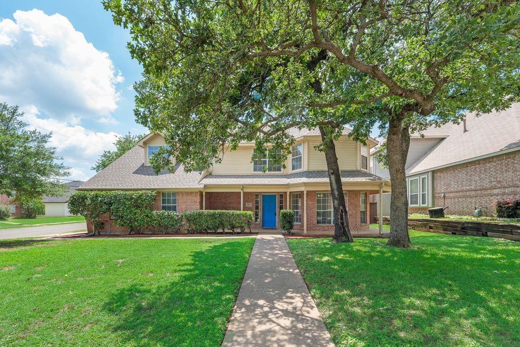 5610 Eagle Rock Road Arlington, TX 76017 - Photo 4 of 33 Two-story residence featuring a brick and siding exterior, a covered porch, and a bright blue front door