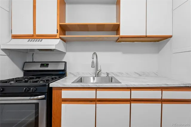 a kitchen with kitchen island a sink a stove and a microwave